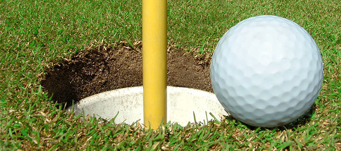 Golfball am Hole auf den Green